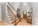 Bright foyer with a striking staircase, decorative glass door and elegant furnishings at 1003 Red Sunset Dr, Apex, NC 27502