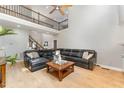Expansive living room features a soaring ceiling, dark leather sofa, and a cozy fireplace at 1003 Red Sunset Dr, Apex, NC 27502