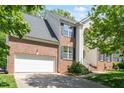 Lovely two-story brick home showcasing an attached garage, a concrete driveway, and well-manicured landscaping at 1007 Grandover Dr, Durham, NC 27713