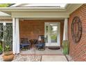 Inviting covered front porch with seating area, decorative accents and brick surround at 102 Fairgrove Way Way, Cary, NC 27511