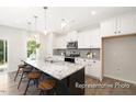 Modern kitchen with a large island featuring seating, white cabinets, and stainless steel appliances at 104 S Buggy Dr # 71P, Benson, NC 27504