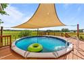 Enjoy the above ground pool, deck, and sunshade overlooking green pastures beyond the backyard fence at 106 Contender Dr, Clayton, NC 27520