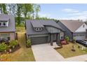 Aerial view of a modern gray home with well manicured lawn and professional landscaping in a quiet neighborhood at 109 Imagine Way, Pittsboro, NC 27312