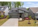 Charming gray home with modern architectural features and colorful flowers in the front yard at 109 Imagine Way, Pittsboro, NC 27312