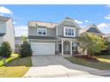 Inviting two-story home featuring a two-car garage, covered porch, and charming curb appeal at 114 Red Robin Rd, Durham, NC 27703