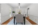Elegant dining room with hardwood floors, decorative mirror, and a modern chandelier above a dining table at 128 Cobblestone Dr, Chapel Hill, NC 27516