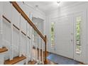 Bright foyer featuring hardwood floors, white trim, and a staircase with wood railing and white risers at 128 Cobblestone Dr, Chapel Hill, NC 27516