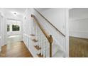 Bright staircase featuring carpeted steps and a wooden handrail at 128 Cobblestone Dr, Chapel Hill, NC 27516