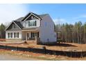 New two-story home with board and batten siding and a brick foundation on a construction lot at 1403 Reading Ct # 75 Kl, Burlington, NC 27217