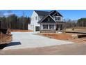 New two-story home with board and batten siding and a concrete driveway on a construction lot at 1403 Reading Ct # 75 Kl, Burlington, NC 27217