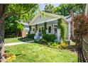 Quaint home featuring a landscaped front yard, covered porch, brick chimney, and traditional architectural details at 1714 Carson St, Raleigh, NC 27608