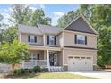 Beautiful two-story home with a welcoming front porch and a well-manicured lawn at 180 Long Grass Dr, Smithfield, NC 27577