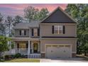 Lovely two-story home featuring a covered front porch beneath a captivating dusk sky at 180 Long Grass Dr, Smithfield, NC 27577