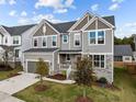 Inviting two-story home with neutral siding, stone accents, a two-car garage, and landscaped front yard at 1816 Sandoval Dr, Durham, NC 27703