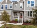 Close-up of a charming home entrance featuring a red front door, stone accents, and well-maintained landscaping at 1816 Sandoval Dr, Durham, NC 27703