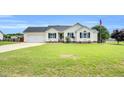 Well-maintained single-story home with an attached garage, blue shutters, and a lush front lawn at 182 Jesse Dr, Smithfield, NC 27577