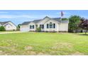 Well-manicured single-story home with attached garage, complemented by a lush front lawn at 182 Jesse Dr, Smithfield, NC 27577