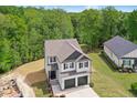 Beautiful two-story home with a two-car garage, set against a lush backdrop of trees at 185 Millwood Dr, Clayton, NC 27527