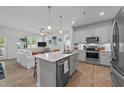 Open-concept kitchen with a center island, stainless steel appliances, and wood laminate flooring at 191 Enterprise Dr, Clayton, NC 27520