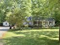 Home exterior featuring a well-manicured lawn with a house, garage, and driveway at 192 Misty Hollow Rd, Timberlake, NC 27583