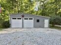 Exterior shot of a two-car garage with white doors, gray siding, and concrete parking pad at 192 Misty Hollow Rd, Timberlake, NC 27583