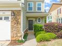 Inviting front entry with stone accents, stylish lighting, and lush landscaping at 201 Mayfield Dr, Apex, NC 27539