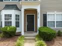 Charming front entrance features brick accents and decorative shrubs at 2713 Wyntercrest Ln, Durham, NC 27713