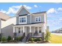 Charming two-story home featuring a welcoming front porch with stone accents and beautifully landscaped yard at 2919 Winter Crop Way, Apex, NC 27502