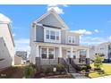 Charming two-story home featuring a welcoming front porch with stone accents and beautifully landscaped yard at 2919 Winter Crop Way, Apex, NC 27502