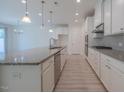 Modern kitchen features white cabinets, granite countertops, and stainless steel appliances at 311 Alamosa Pl, Cary, NC 27519