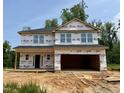 Two-story home under construction featuring a two-car garage and visible framing against a clear sky backdrop at 327 Bishop Ln, Sanford, NC 27330