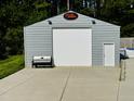 Spacious detached garage with a large roll-up door and a side entrance at 3605 Mine Creek Rd, Burlington, NC 27217