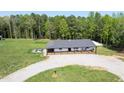 Aerial view of a cozy home, with a spacious yard, a porch, and surrounded by lush greenery at 435 Salt And Light Ln, Henderson, NC 27537