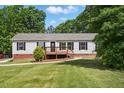 Inviting single-story home with a wooden porch, complemented by a lush green lawn at 4467 Virgilina Rd, Roxboro, NC 27574