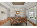 Open dining room with decorative lighting and views of the backyard at 5009 Coe Hill Pl, Cary, NC 27519