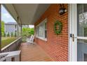 Inviting front porch with rocking chairs, brick accent wall, and charming outdoor lighting at 5144 Jeffries St, Raleigh, NC 27606