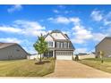 Beautiful home with a two-car garage, manicured lawn, and a young tree in the front yard at 5525 Garnet Meadow Rd, Knightdale, NC 27545