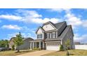 Charming two-story home with a well-kept lawn, mature tree, and a two-car garage at 5525 Garnet Meadow Rd, Knightdale, NC 27545