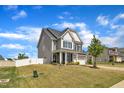 Attractive two-story home with a manicured lawn, white fence, and a two-car garage at 5525 Garnet Meadow Rd, Knightdale, NC 27545