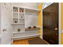 Foyer featuring hardwood floors, a decorative shelving unit, and a dark-colored front door with a storm door at 6 Chelan Ct, Durham, NC 27713