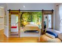Main bedroom with mural backdrop and sliding barn doors looking into the living room at 6 Chelan Ct, Durham, NC 27713