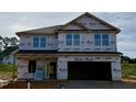 Unfinished two-story home featuring a two-car garage and multiple windows at 606 Melrose Ct, Sanford, NC 27330