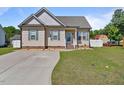 Charming single-story home boasts a manicured lawn, a concrete driveway, and classic curb appeal at 608 W Godwin St, Dunn, NC 28334