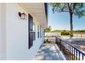 Inviting side porch with black railings and white brick exterior creating a welcoming entrance at 6715 Princeton Kenly Rd, Princeton, NC 27569