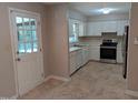 Functional kitchen with white cabinets, stainless steel appliances, and access to a back porch at 710 E Azalea Ct, Fuquay Varina, NC 27526