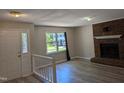 Inviting living room with hardwood floors, brick fireplace, and a window overlooking the landscaped front yard at 710 E Azalea Ct, Fuquay Varina, NC 27526