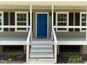 Close-up of a home's entrance with a bright blue door and white-railed porch at 717 Papsworth Ct, Fuquay Varina, NC 27526