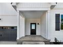 View of the home's entry way, showing a sleek black door with glass and modern design elements at 72 Glenwood Pl, Kenly, NC 27542