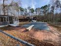 Backyard swimming pool with an adjacent deck and covered pavilion, set against a backdrop of mature trees at 80 White Deer Ln, Henderson, NC 27537