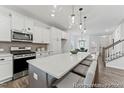 Bright kitchen featuring a center island, pendant lighting, stainless appliances and views to the living room and stairs at 105 S Mule Way # 89, Benson, NC 27504